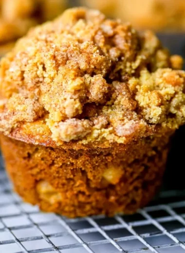 Freshly baked apple cinnamon muffins on a wooden table