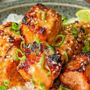 Delicious cozy Bang Bang Salmon served with a creamy sauce and vibrant vegetables.