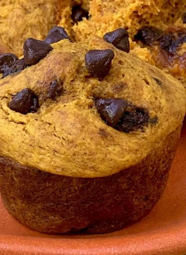 Cozy Greek yogurt pumpkin muffins fresh out of the oven with spices and toppings.