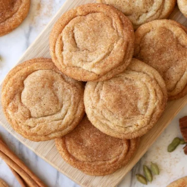 Cozy chai snickerdoodles cookies arranged on a plate with a cup of chai tea.