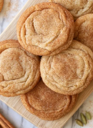 Cozy chai snickerdoodles cookies arranged on a plate with a cup of chai tea.