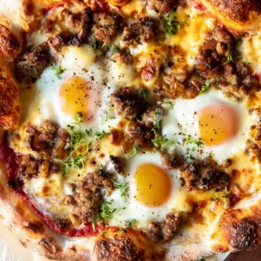 A delicious sausage breakfast pizza topped with eggs and cheese for a perfect morning meal