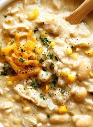 Bowl of cozy white chicken chili topped with fresh herbs and cheese
