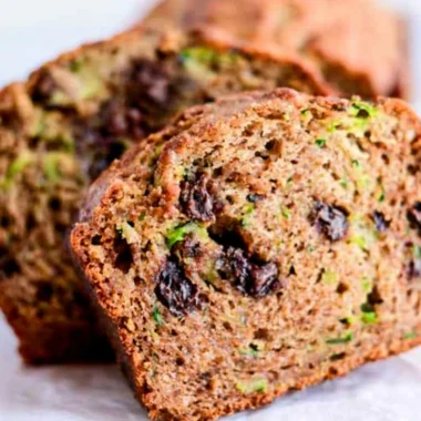 Loaf of chocolate chip zucchini bread with chocolate chips and fresh zucchini
