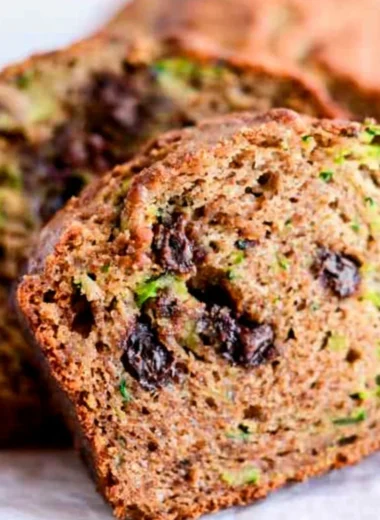 Loaf of chocolate chip zucchini bread with chocolate chips and fresh zucchini