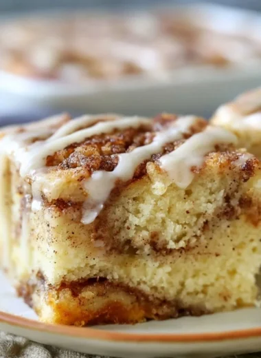 Cozy cinnamon roll cake fresh out of the oven, topped with creamy frosting.