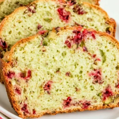 Cozy Cranberry Pistachio Bread fresh out of the oven, topped with cranberries and pistachios.