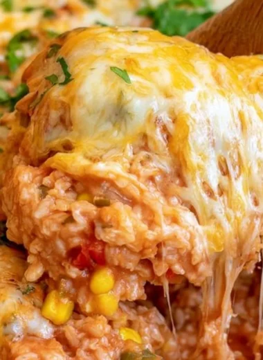 Delicious cheesy enchilada rice in a bowl, garnished with fresh herbs.