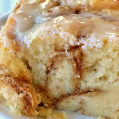 Homemade cinnamon roll cake topped with icing and cinnamon swirl