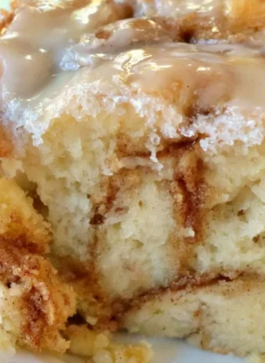 Homemade cinnamon roll cake topped with icing and cinnamon swirl