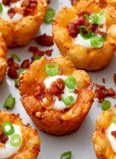 Loaded Tater Tot Cups topped with cheese and toppings for a tasty appetizer.