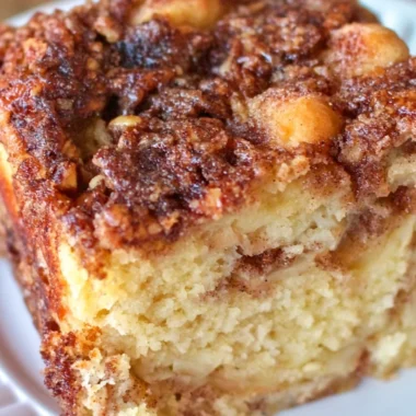 A slice of moist Apple Sour Cream Cake topped with fresh apple slices