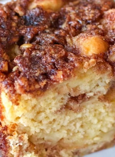 A slice of moist Apple Sour Cream Cake topped with fresh apple slices