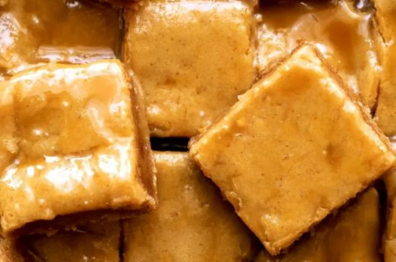 Delicious maple blondies topped with a decadent maple glaze on a rustic table.