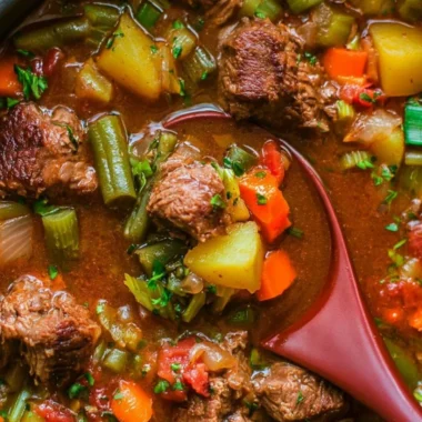 A bowl of cozy vegetable beef soup featuring vegetables and beef in a savory broth.