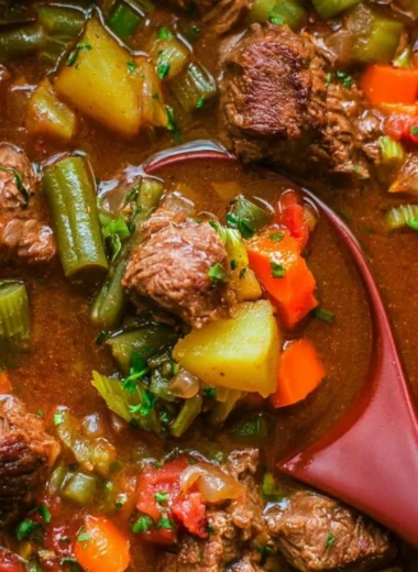 A bowl of cozy vegetable beef soup featuring vegetables and beef in a savory broth.