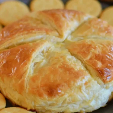 Tasty Baked Brie in Puff Pastry served with fruits and nuts.