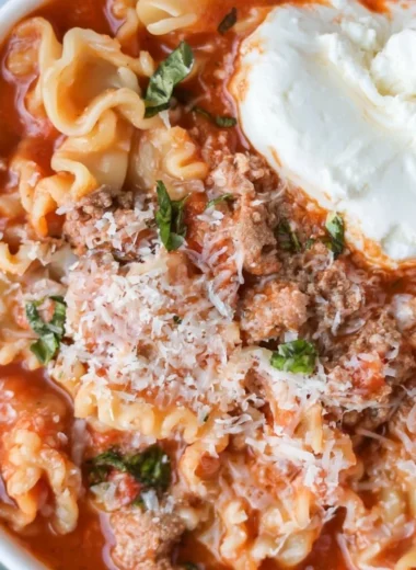 Delicious and healthy lasagna soup in a bowl topped with cheese and herbs