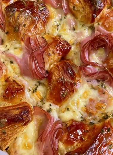 Delicious croissant bake casserole served on a plate with fresh garnishes
