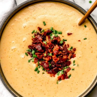 Bowl of high-protein cream of potato soup with herbs and toppings