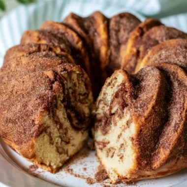 Moist cinnamon coffee cake served on a plate with a fork