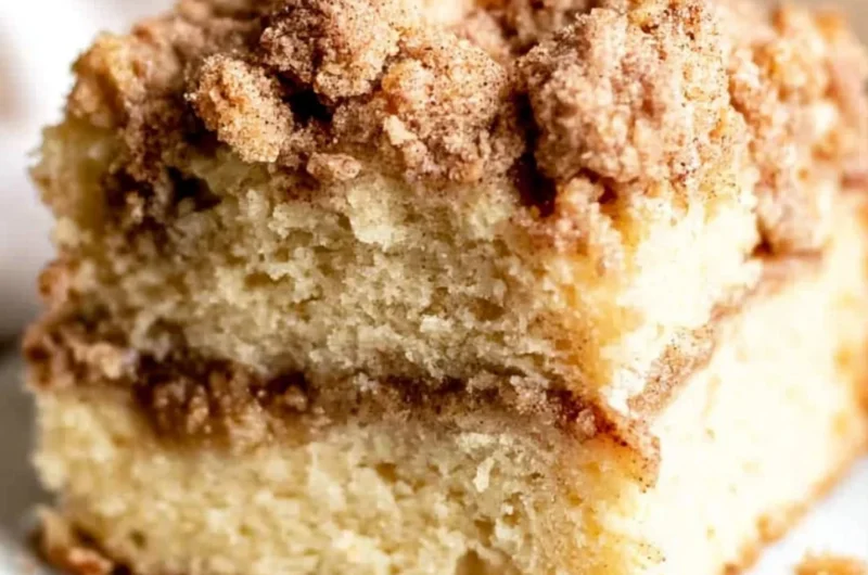 Sour Cream Coffee Cake topped with cinnamon and served on a plate
